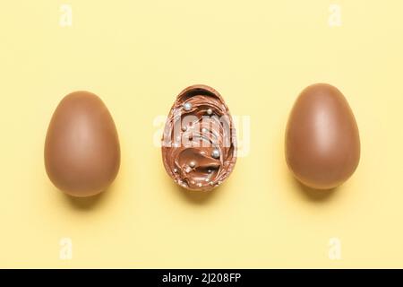 Delicious chocolate eggs with paste filling on yellow background Stock Photo