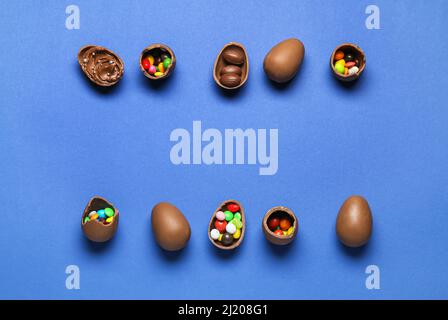 Delicious chocolate eggs with different fillings on blue background Stock Photo