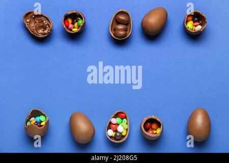 Delicious chocolate eggs with different fillings on blue background Stock Photo