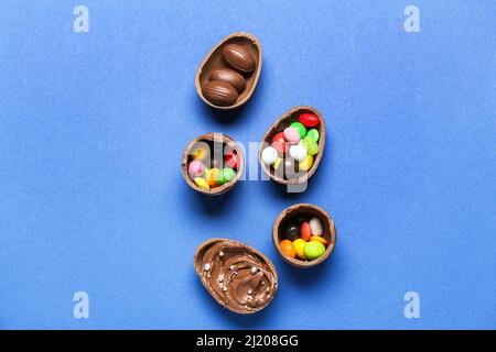 Delicious chocolate eggs with different fillings on blue background Stock Photo
