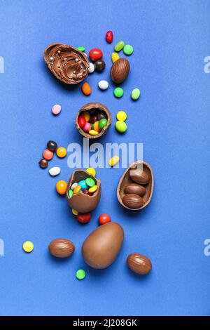 Delicious chocolate eggs with different fillings on blue background Stock Photo