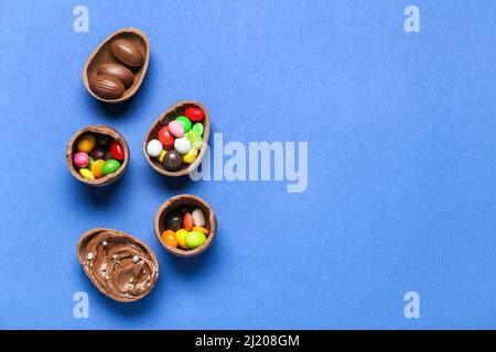 Delicious chocolate eggs with different fillings on blue background Stock Photo