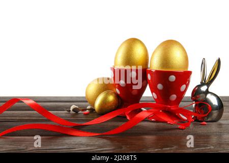 Painted Easter eggs and figurine of bunny on table against white background Stock Photo