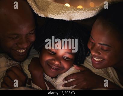 The tiniest moment can create the biggest memory. Shot of a young family bonding at home. Stock Photo