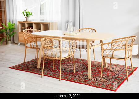 Interior of light dining room with table and vintage carpet Stock Photo