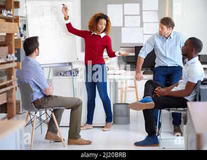 Getting their creativity revved up. Shot of a group of designers talking together in a presentation. Stock Photo