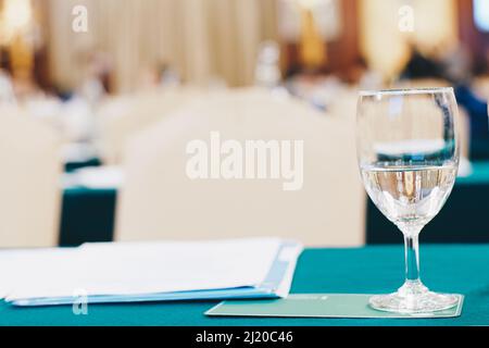 Drinkking water in wine glass on table of meeting room blurred background Stock Photo