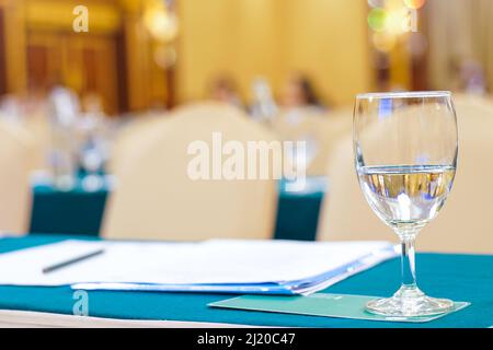 Drinkking water in wine glass on table of meeting room blurred background Stock Photo