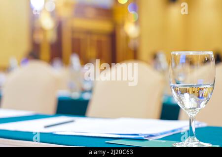 Drinkking water in wine glass on table of meeting room blurred background Stock Photo