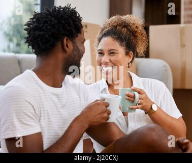 The prospect of going home is very appealing. Shot of a couple drinking coffee in their new home. Stock Photo