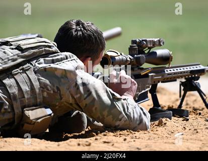 A competitor in the United States Army Special Operations Command (USASOC) International Sniper Competition, ejects a spent cartridge after engaging long-distance targets at Fort Bragg, North Carolina, March 21, 2022. Twenty-one teams competed in the the 13th annual USASOC International Sniper Competition where instructors from the United States Army John F. Kennedy Special Warfare Center and School designed a series of events that challenged the two-person team's ability to work together with speed and accuracy while engaging targets from multiple distances in varied types of environments. (U Stock Photo