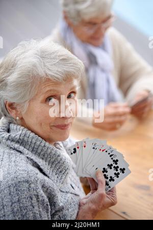 Helping the time pass with card games. Shot of senior citizens playing cards together. Stock Photo