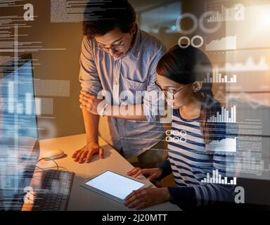 Using different devices to crack these codes. Shot of computer programmers looking through data in the office. Stock Photo