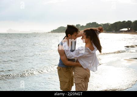 Embracing young lovers dancing on the beach - stock photo Stock Photo