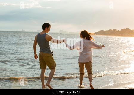 Young couple filling message in drift bottle on summer beach - stock photo Stock Photo