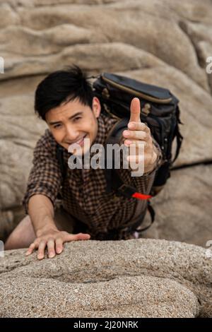 Climber reaching out to his partner for help - stock photo Stock Photo