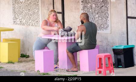 Galle, Sri Lanka - 02 15 2022: Couple enjoying a fresh beverage sitting on the outdoor benches. Stock Photo