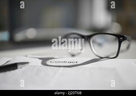 Close up of contract paperwork on desk with glasses Stock Photo