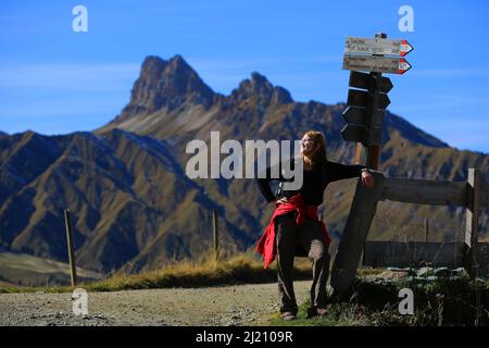 Dolomiten, schöne Frau beobachtet von der  Seiser Alm die  Berge und Felsen am  Langkofel oder Sasso Lungo in Südtirol in den Dolomiten Stock Photo