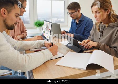 Diverse employees work on gadgets in office Stock Photo