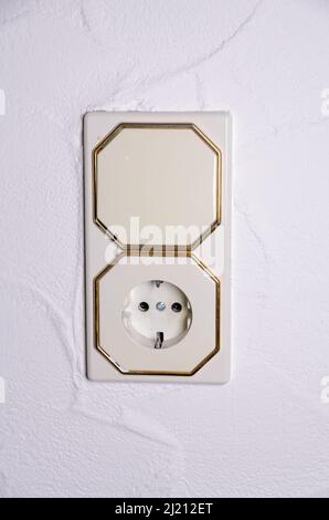 Modern light switch and german power outlet or socket on white wall indoors, Germany, Europe Stock Photo