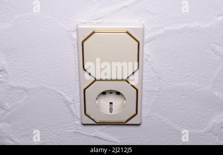 Modern light switch and german power outlet or socket on white wall indoors, Germany, Europe Stock Photo