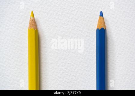 Blue and yellow colored pencils on rough paper. Blue and yellow are colors of Ukraine national flag. Stock Photo