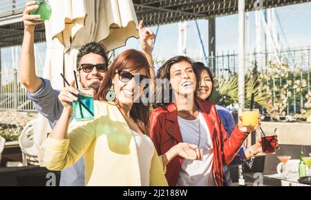 Fashion people dancing music and having fun together at beach party - Happy young friends drinking cocktail at fancy summer bar festival - Amusement c Stock Photo