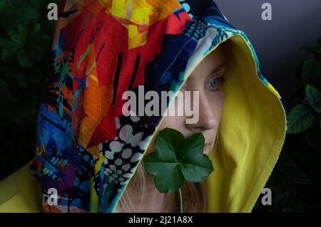 Woman with a colorful hood among the greens Stock Photo