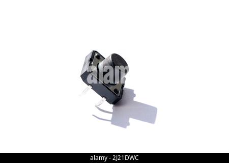 A macro portrait of a small push button. The electric component is used in electronics on a on PCB or circuit boards. When the button is pressed, it a Stock Photo