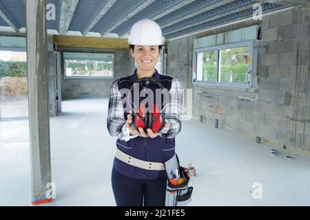 portrait of female worker holding earmuffs Stock Photo