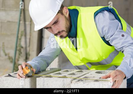 brickmason calculating the distance between bricks Stock Photo