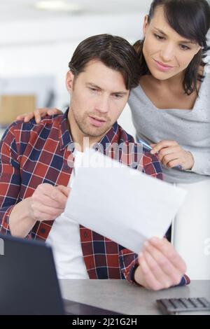 unhappy couple arguing about money bills documents Stock Photo