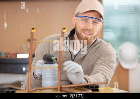 young man working on copper pipes Stock Photo