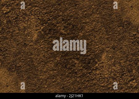 Rough textured dark brown color old stone wall surface Stock Photo