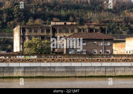 Ruined abandoned industrial building on the Nervion River in Bilbao Stock Photo