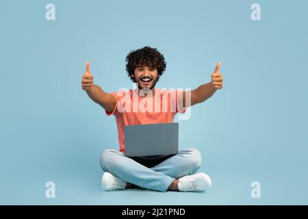 Positive hindu guy enjoying newest computer software Stock Photo