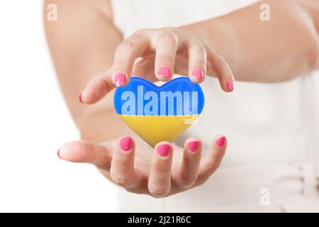 Save Ukraine Concept. Two Woman Hands Protecting Heart with Ukraine Flag on a white background. 3d Rendering Stock Photo