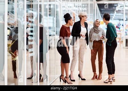 They share a solid friendship as colleagues. Shot of a group of businesswomen chatting to each other in an office. Stock Photo