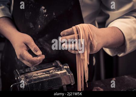 The chef makes fresh spaghetti from scratch. Stock Photo