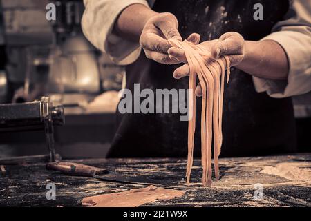 The chef makes fresh spaghetti from scratch. Stock Photo