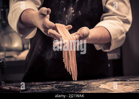 The chef makes fresh spaghetti from scratch. Stock Photo