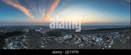 Aerial scenic panoramic view over early spring natural bog wetland with frozen pools and scenic sunrise in the sky Stock Photo