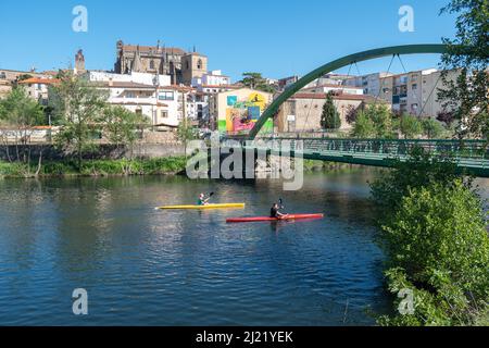 Plasencia, Spain - April 17, 2021: Two young man practices canoeing riding in his canoe navigating the Jerte river Stock Photo