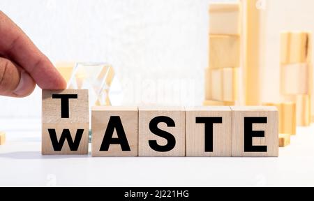 From waste to taste. Hand turns a dice and changes the word waste to taste. Stock Photo