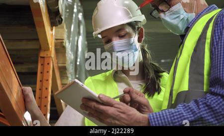 Female and male engineers wear safety helmets in the storage room Stock Photo
