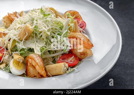 Caesar salad with shrimps, on a dark background. Stock Photo