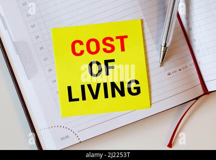 Conceptual hand writing showing Cost Of Living. Business photo text The level of prices relating to a range of everyday items Striped paperboard cardb Stock Photo