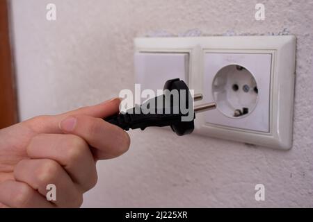 Closeup hand inserting the plug into the outlet. Stock Photo