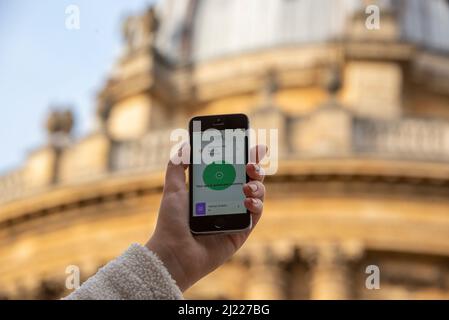 Using the NHS Covid app on an iPhone outside the Radcliffe Camera, Oxford, UK Stock Photo